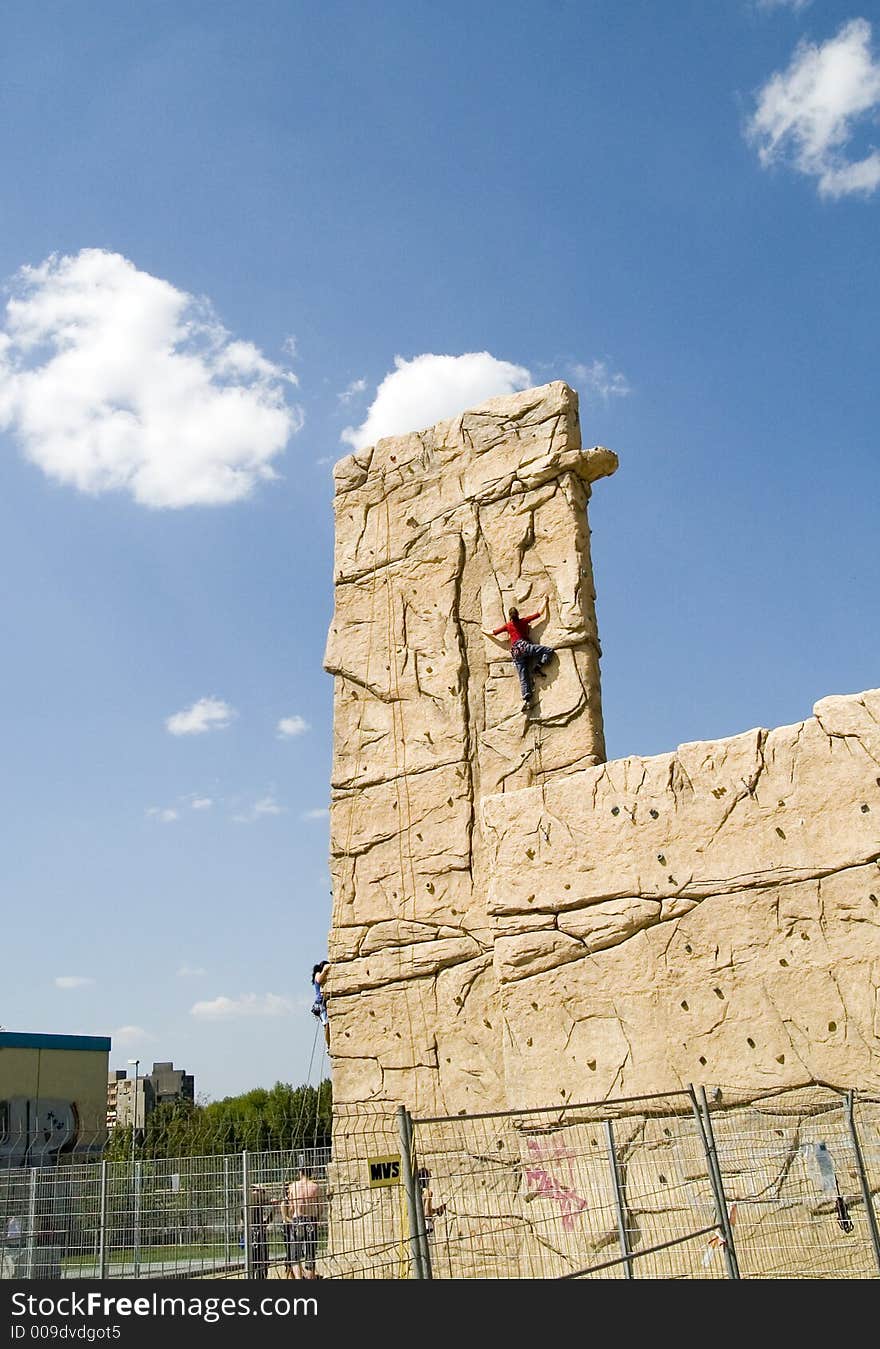 Two young woman climb a climbing wall. They are secured by rope, which lead by certain safeguarding points, against a crash. The rope become secured from other mountain climbers. The climbing wall is located in Berlin in the scene quarter “Prenzlauer Berg” in Germany. The photo developed coincidentally during a waiting period bypass in the wonderful summer 2006. Two young woman climb a climbing wall. They are secured by rope, which lead by certain safeguarding points, against a crash. The rope become secured from other mountain climbers. The climbing wall is located in Berlin in the scene quarter “Prenzlauer Berg” in Germany. The photo developed coincidentally during a waiting period bypass in the wonderful summer 2006.