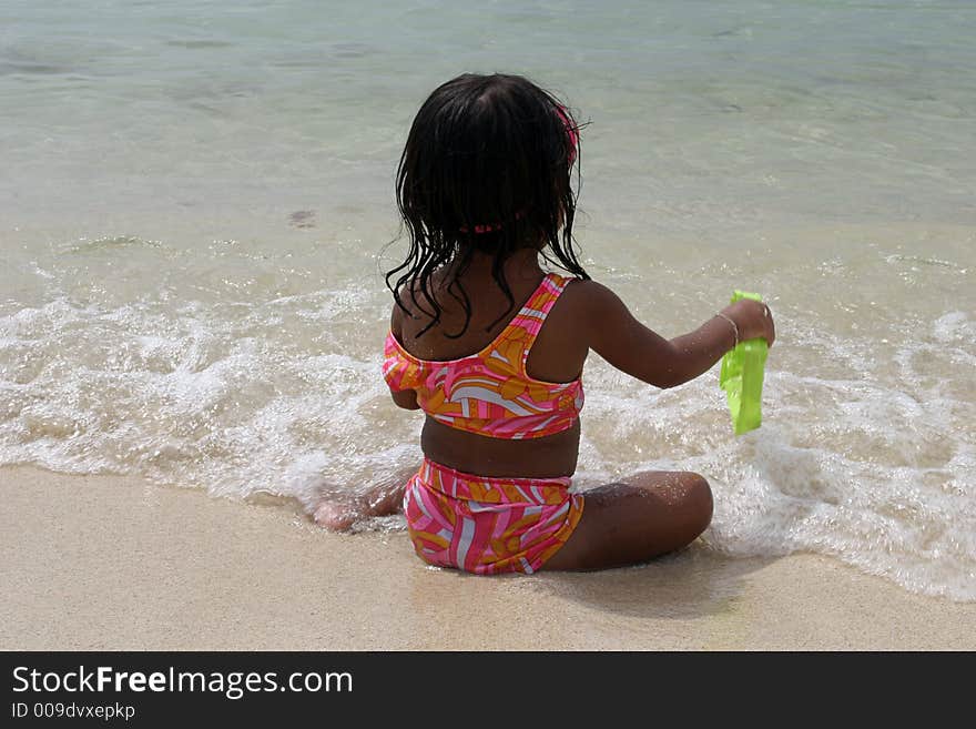 Little girl playing in the sand on a beach. Little girl playing in the sand on a beach