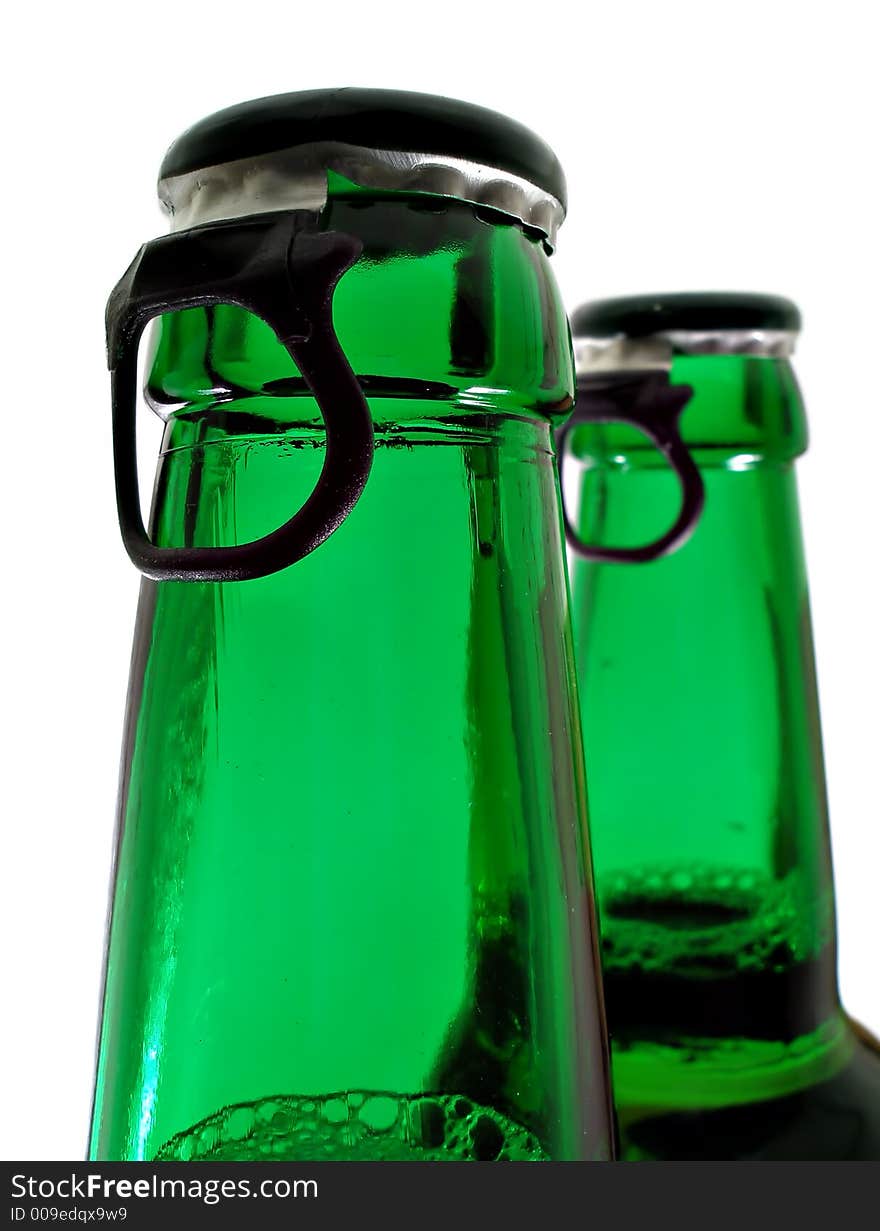 Upper part of two beer bottles isolated over white background. Upper part of two beer bottles isolated over white background