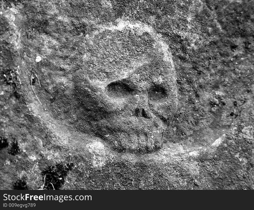 Gravestone with detail of skull in black and white