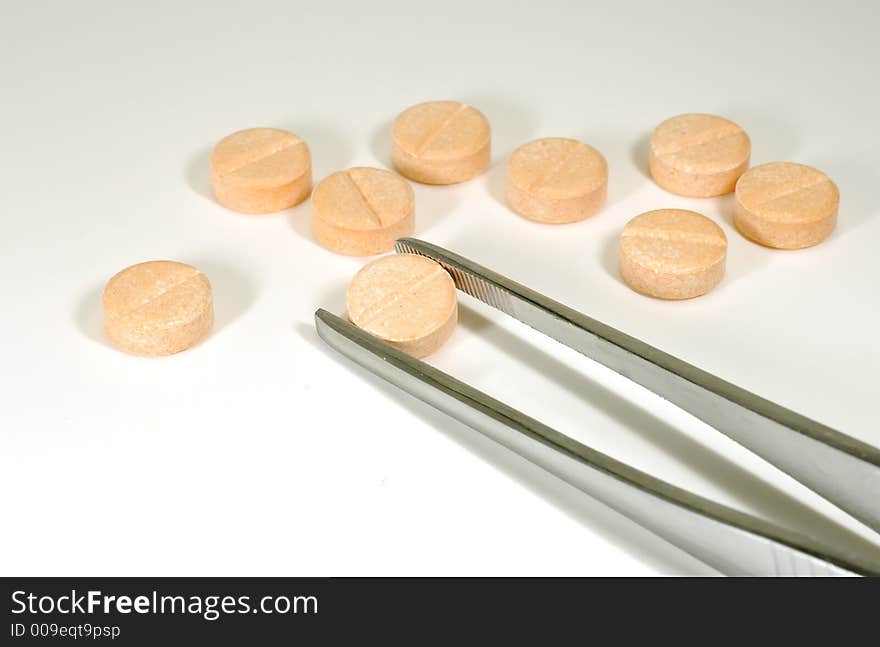 Photo of a Tweezer holding a pill  - Pharmaceutical Related. Photo of a Tweezer holding a pill  - Pharmaceutical Related