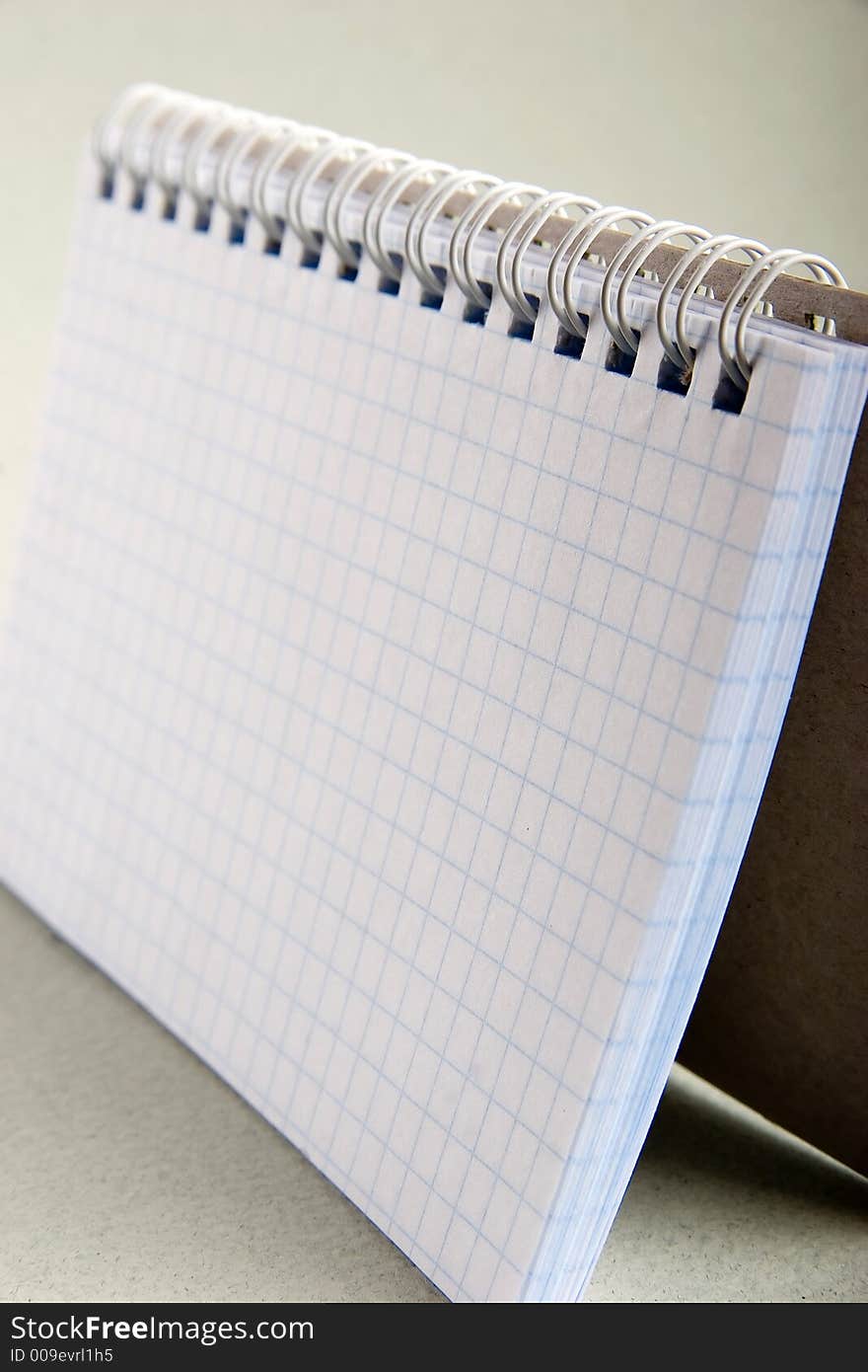 Notebook in a cell with a white metal spring