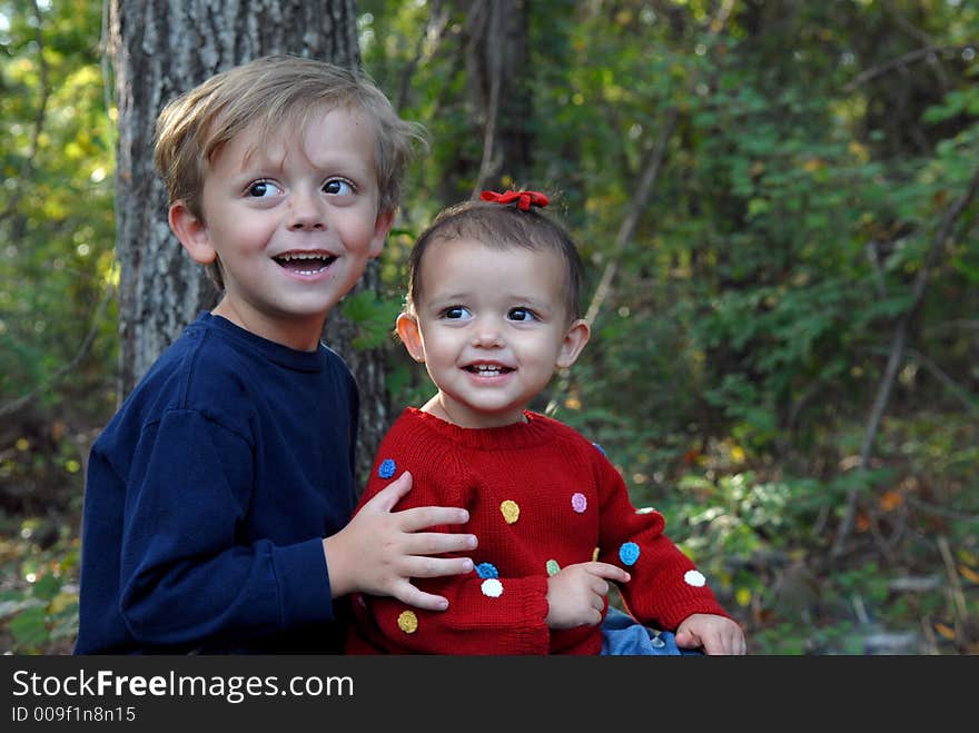 A brother and sister cutting their eyes during a photo shoot. They both have big smiles and big brown eyes. They happy siblings. A brother and sister cutting their eyes during a photo shoot. They both have big smiles and big brown eyes. They happy siblings.