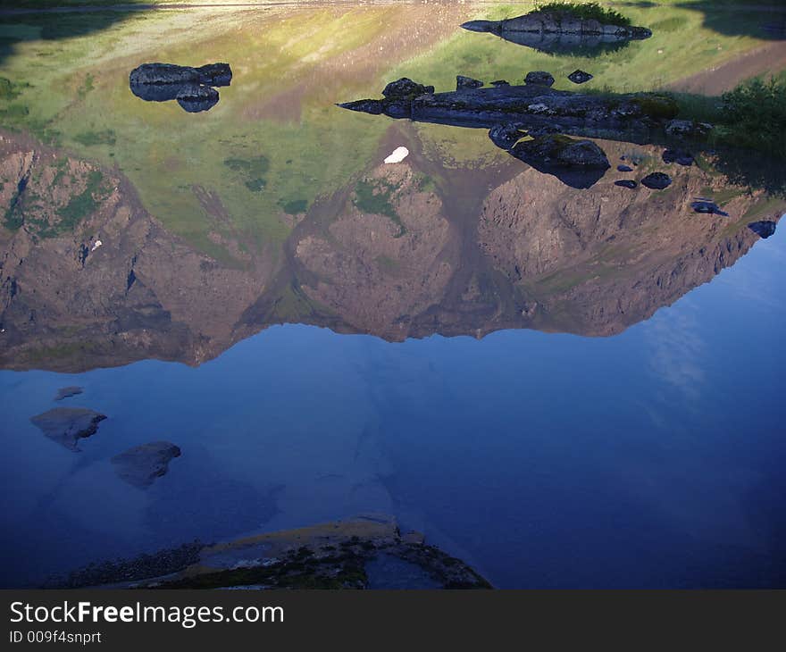 Mountain and sky reflected in alpine lake. Mountain and sky reflected in alpine lake