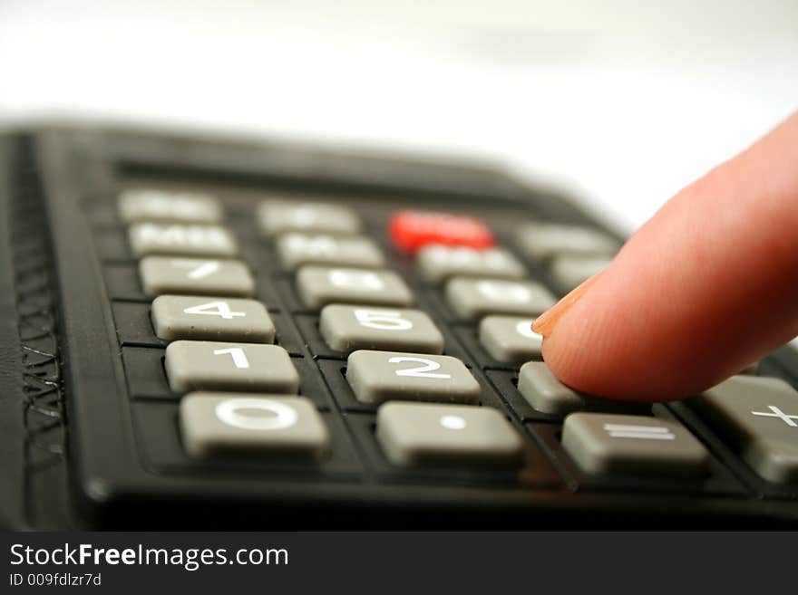 Close up of fingertip on the the keyboard of a calculator. Close up of fingertip on the the keyboard of a calculator.