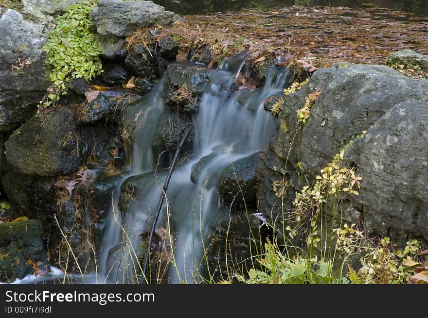 Water fall, backed up with fallen autumn leaves. Water fall, backed up with fallen autumn leaves