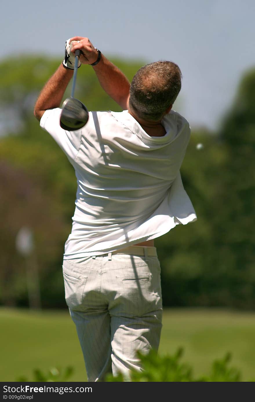 Player hitting a golf ball. Player hitting a golf ball.