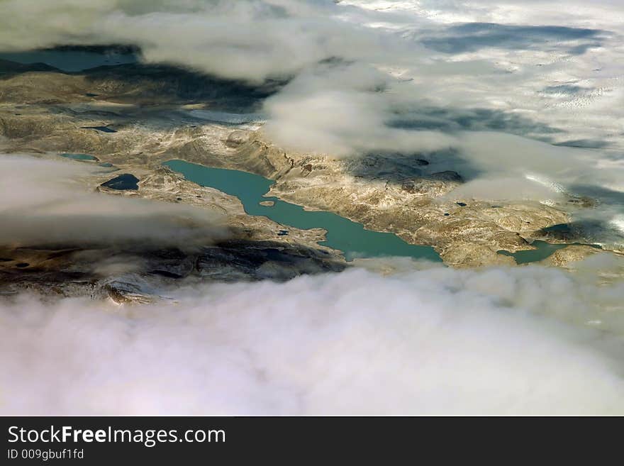 Green mountain lake surrounded by clouds