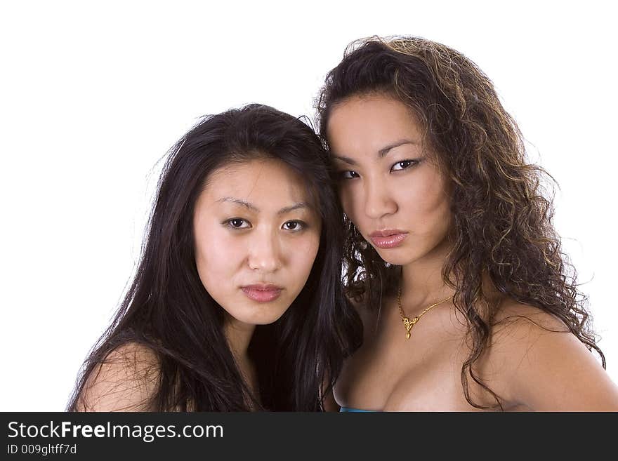 Two beautiful Asian-American women looking angry at the camera. Image isolated on white. Two beautiful Asian-American women looking angry at the camera. Image isolated on white.