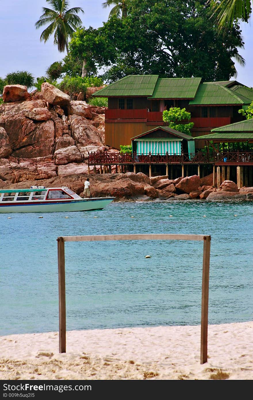 A passenger boat arriving near an island resort in the far distance