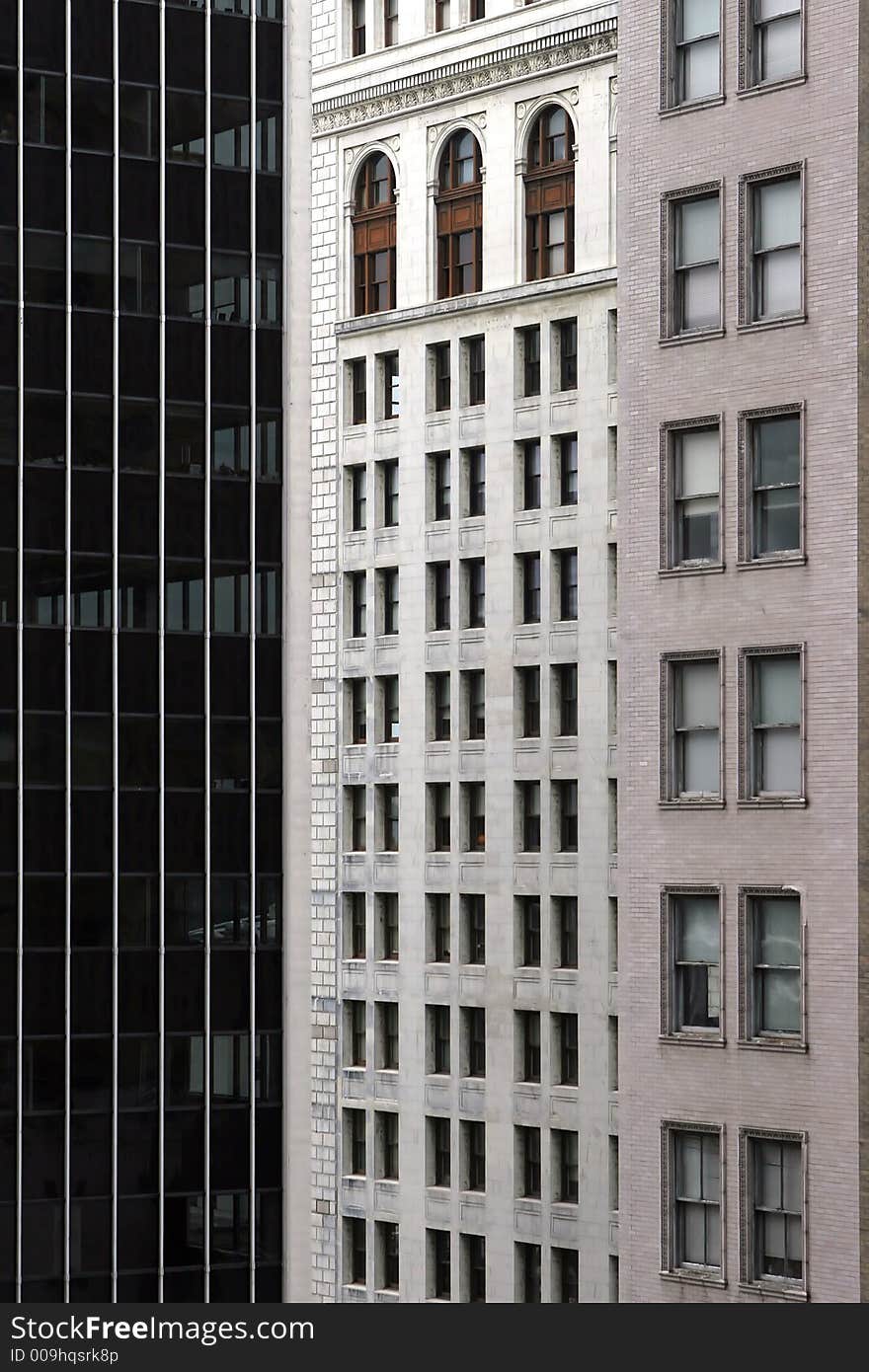 Two older buildings and a skyscraper.