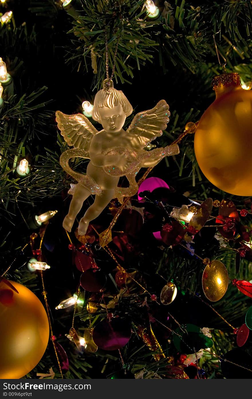 Crystal angel decoration hanging on a christmas tree. Illuminated in golden looking light. Crystal angel decoration hanging on a christmas tree. Illuminated in golden looking light.