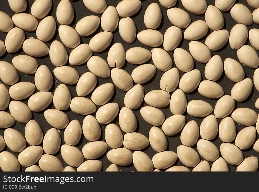 Chicken eggs cut in half and pasted on a wall.  They look like beans but they are really a sculpture like chicken eggs. Chicken eggs cut in half and pasted on a wall.  They look like beans but they are really a sculpture like chicken eggs.