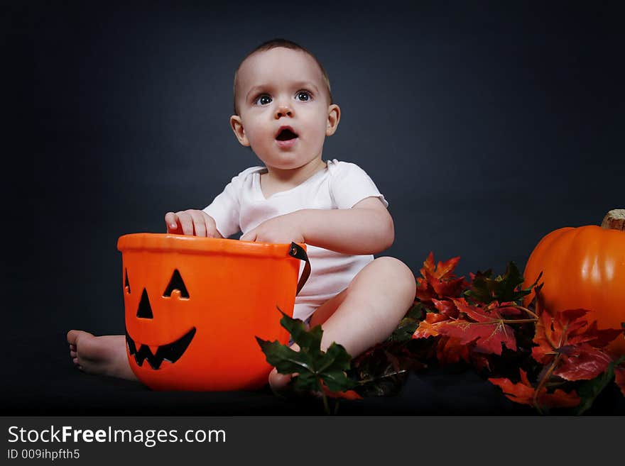 Beautiful baby boy poses on a black background