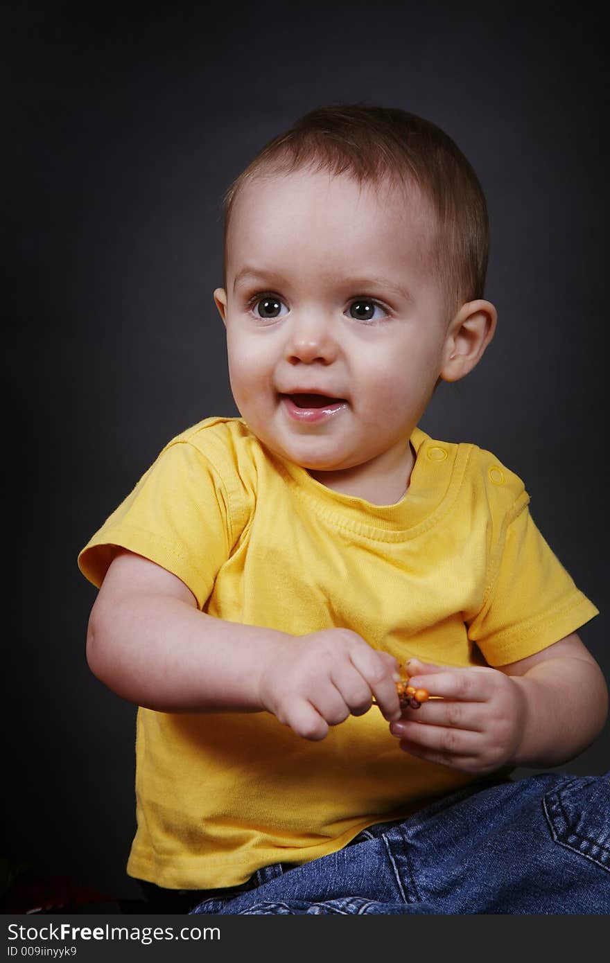 Beautiful baby boy poses on a black background