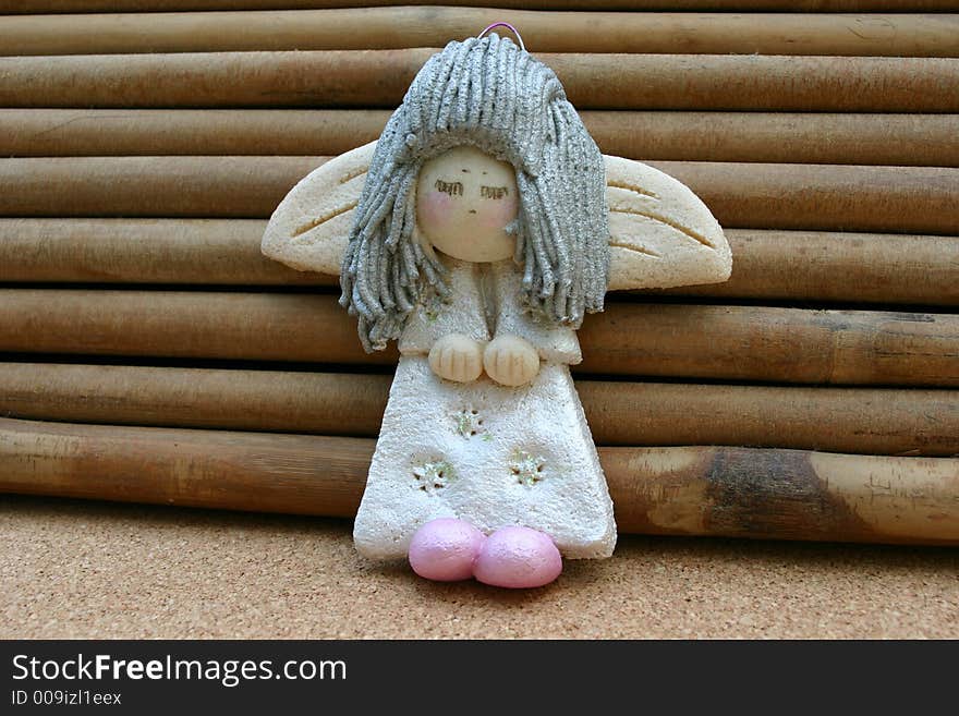 Silver haired shy angel toy keeping his hands and feet together.