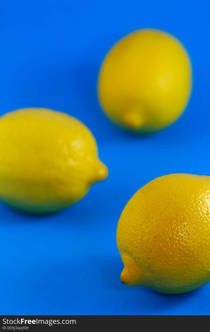 Whole Lemons Over Blue Background. Shallow DOF. Whole Lemons Over Blue Background. Shallow DOF.