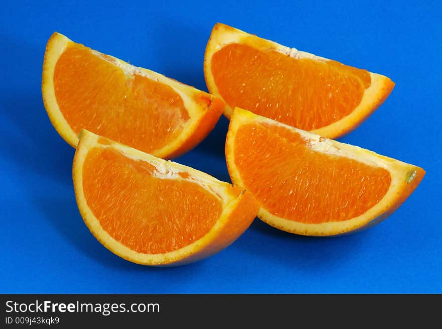 Orange Wedges Over Blue Background. Orange Wedges Over Blue Background