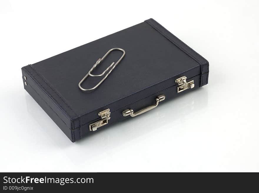 Black toy suitcase with gigantic paper clip ontop