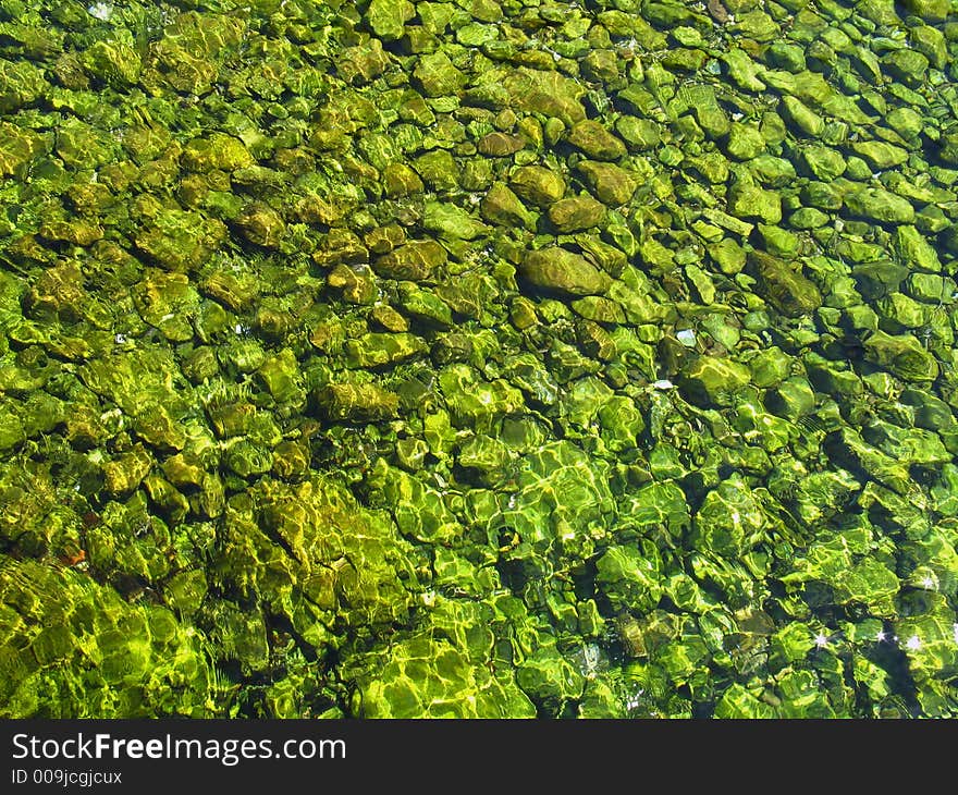 Green stones under the water,  Montenegro country, daylight. Green stones under the water,  Montenegro country, daylight