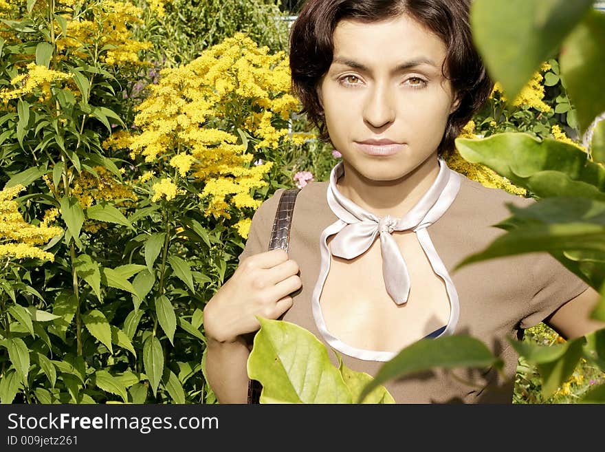 Portrait of a young woman, brunette in a garden-close up