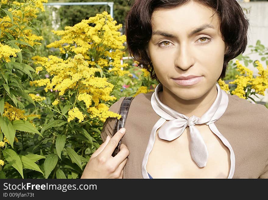 Portrait of a young woman, brunette in a garden-close up