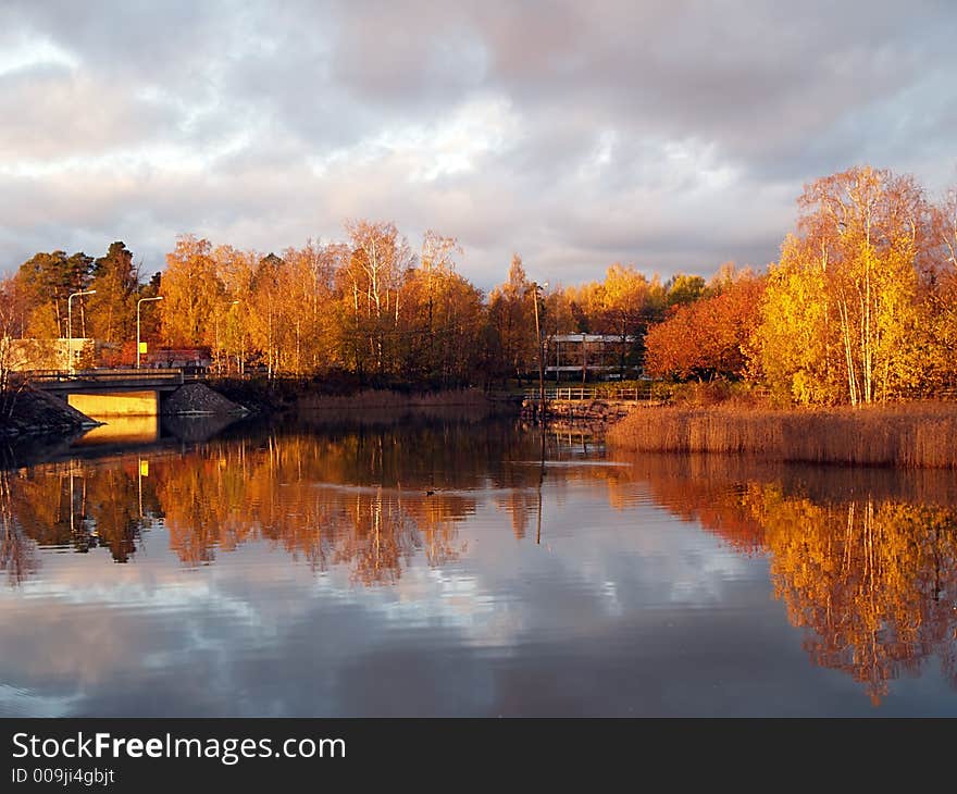 Reflections of trees and clouds on water on sunrise two