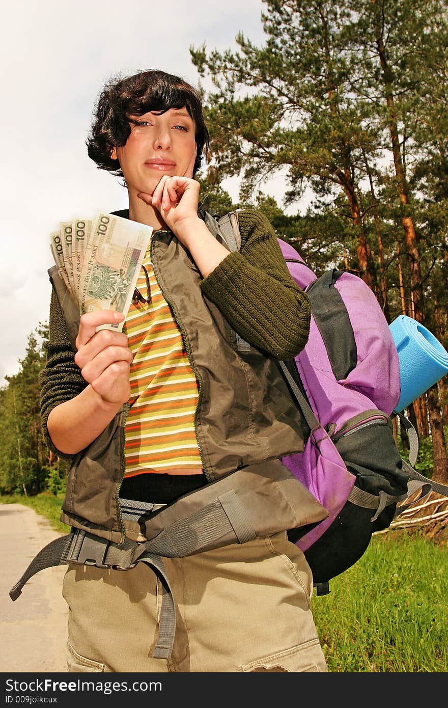 Girl, young woman with a backpack and money for the trip-in a  forest