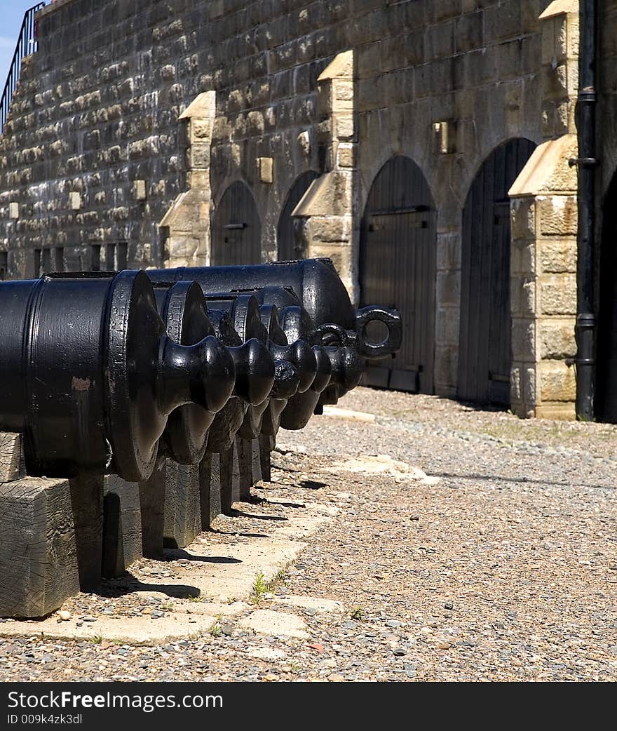 A row of old cannons in a historic fort. A row of old cannons in a historic fort