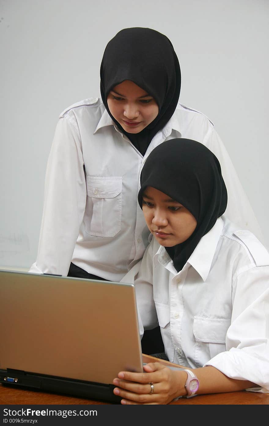 Asian girls using a laptop at the office. Asian girls using a laptop at the office.