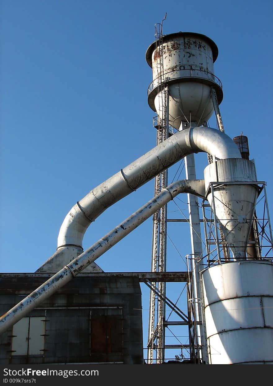 Factory building with water tower and metal pipes