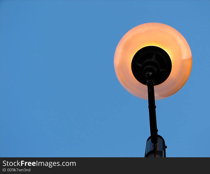 Street light against the clear blue sky, view from below. Space for text. Street light against the clear blue sky, view from below. Space for text.