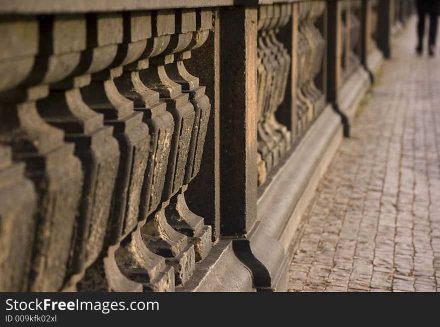 Pillars and man walking away, taken on bridge in prague.