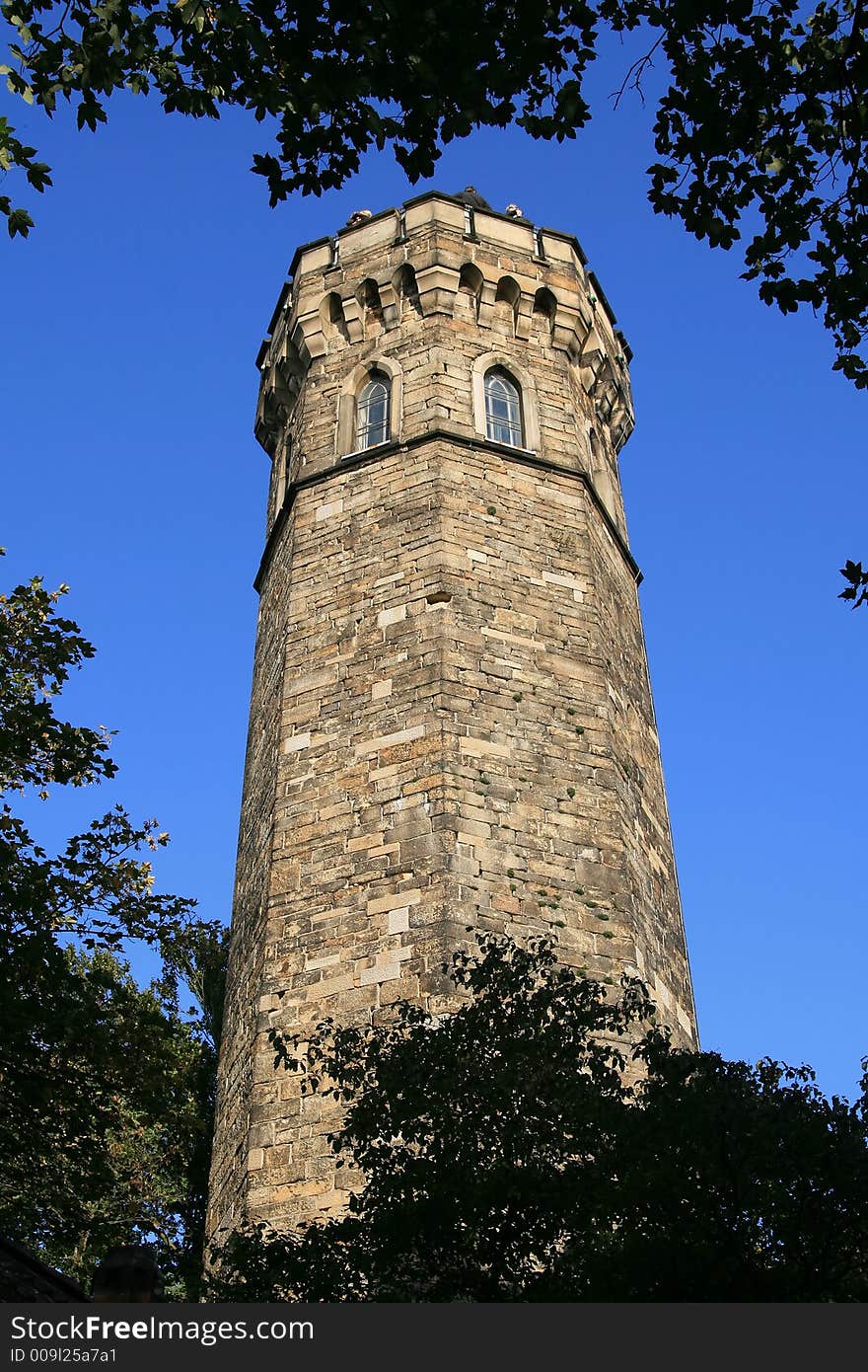 The ancient tower on a background of the bright blue sky is very good as a card