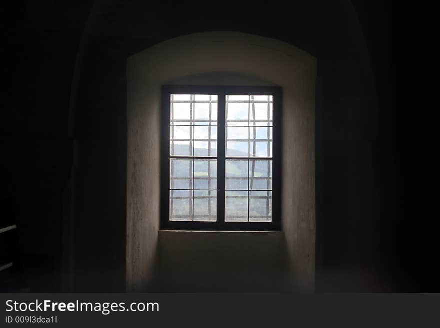 Artistic deep dark window in a castle looking over the alps. Artistic deep dark window in a castle looking over the alps