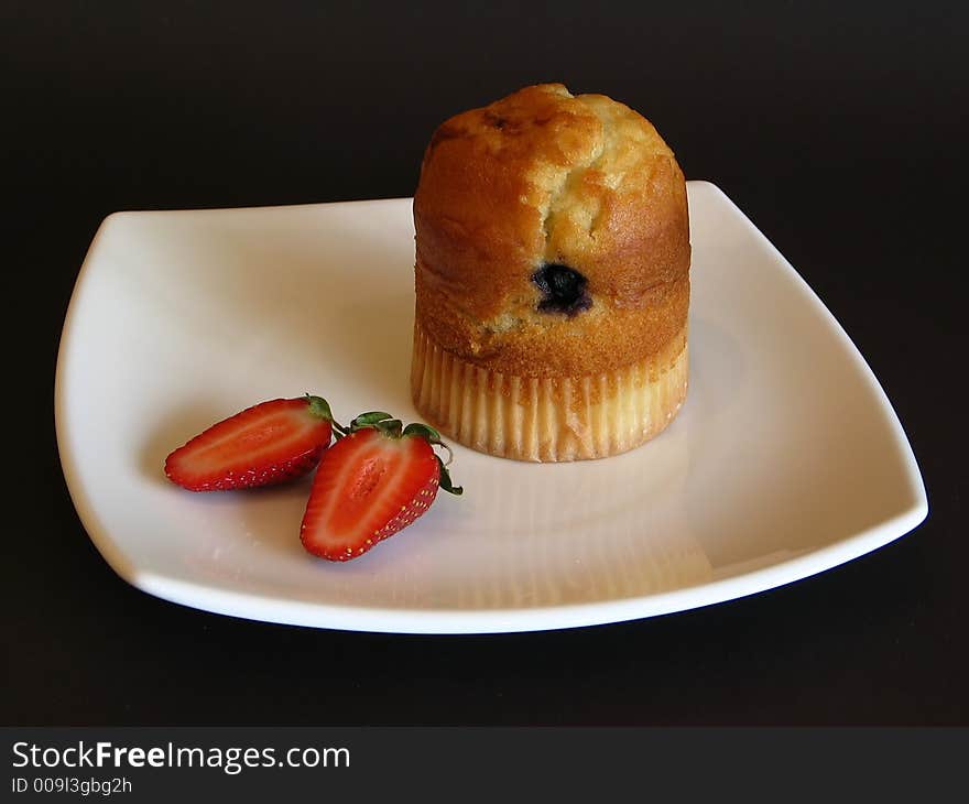 Muffin and strawberry on a white plate. Muffin and strawberry on a white plate