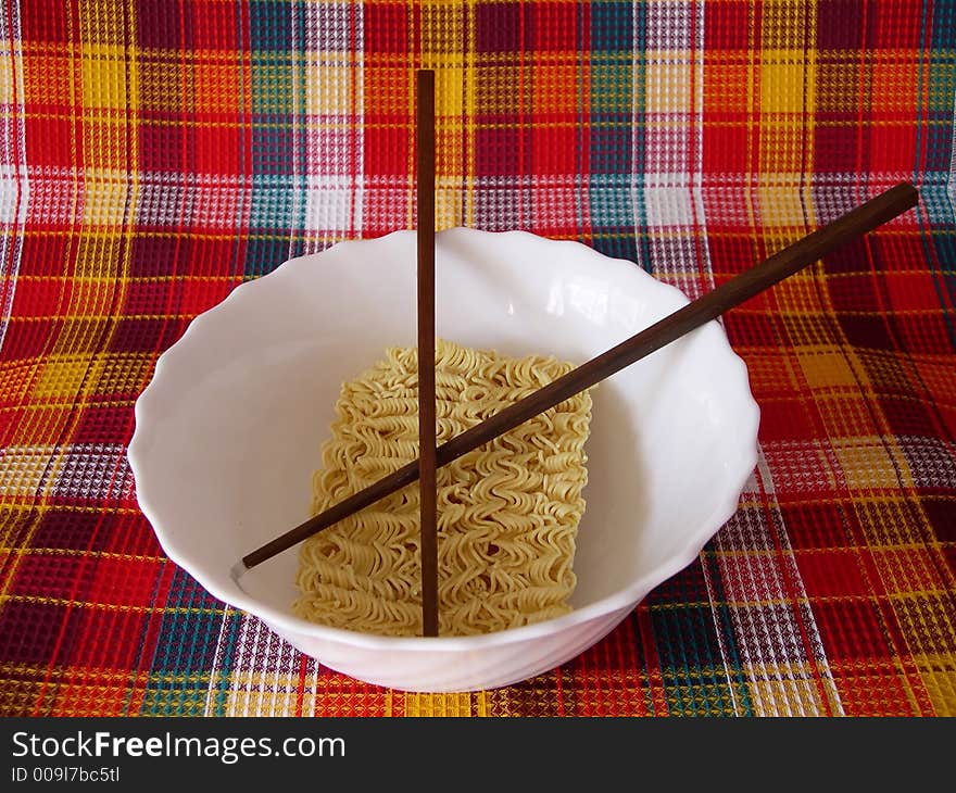 The welded noodles in a bowl with the Chinese sticks