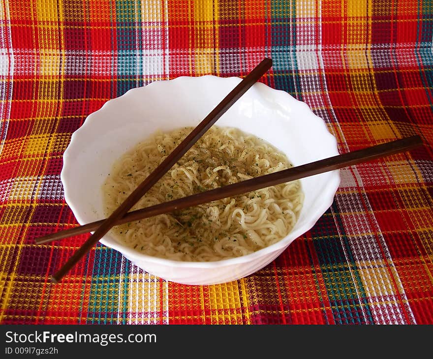 The welded noodles in a bowl with the Chinese sticks