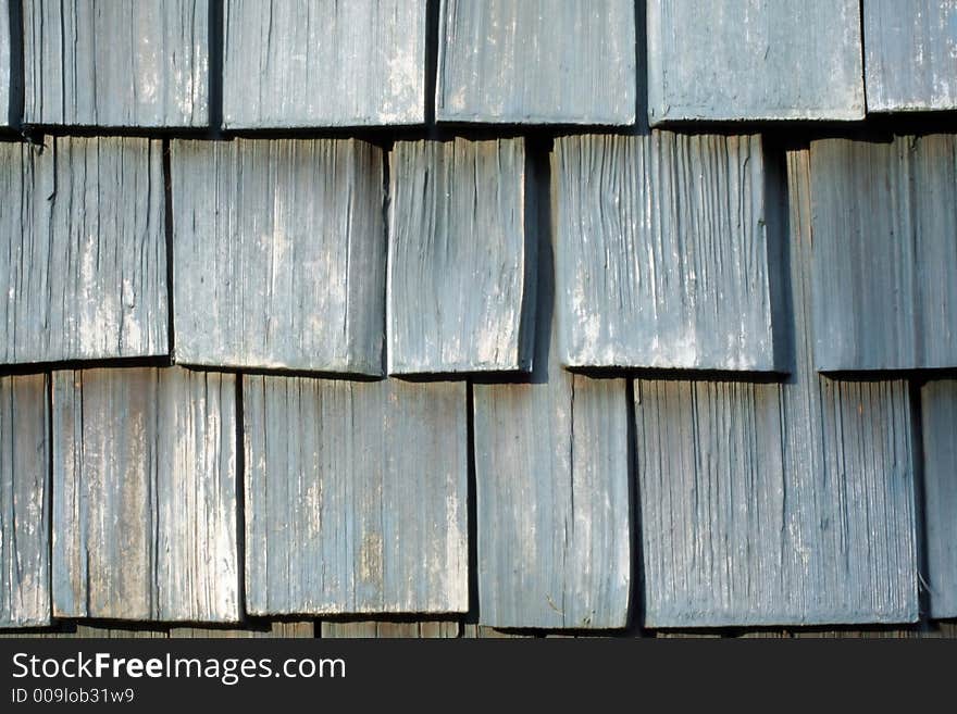 This is a close up image of the weathered wooden shingles on a house.