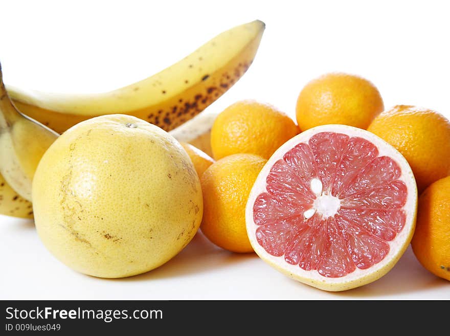 Assorted fruit over white - Includes grapefruit, clementines, bananas