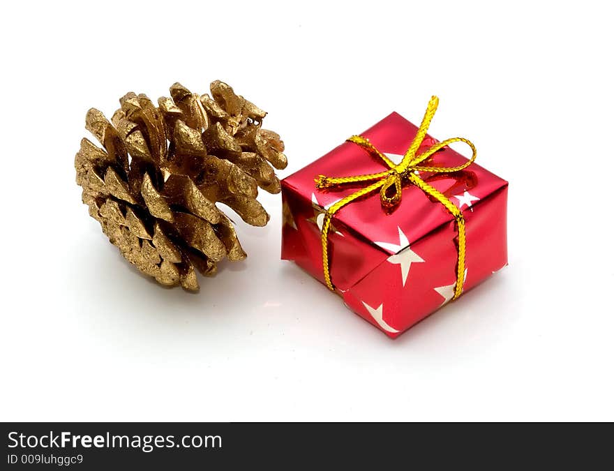 Symbols of christmas, a wrapped gift and a golden pine cone. Symbols of christmas, a wrapped gift and a golden pine cone