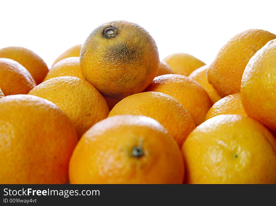 Stack of clementines isolated on white - One rotten on the top