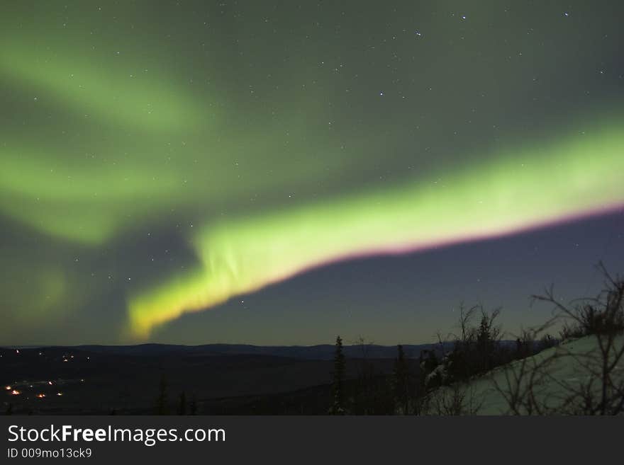 Double color arc of northern lights in the cold night sky. Double color arc of northern lights in the cold night sky