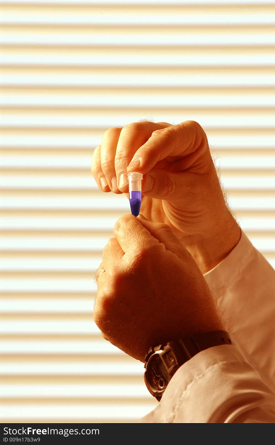 Close up of hands holding laboratory vial. Close up of hands holding laboratory vial