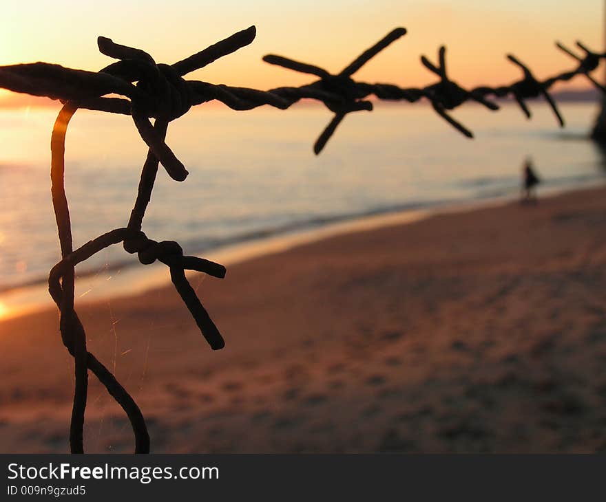 A sunset landascape with sea and barbedwire. A sunset landascape with sea and barbedwire