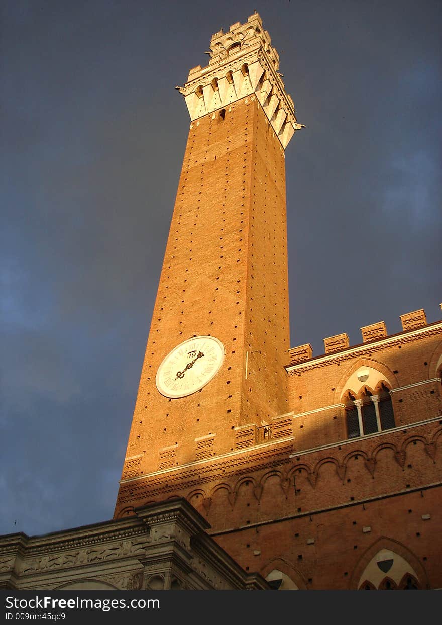 Afternoon of a stormy day in Siena. Grey-violet clouds contrast with the brick walls of Palacio Buensignori. Afternoon of a stormy day in Siena. Grey-violet clouds contrast with the brick walls of Palacio Buensignori.