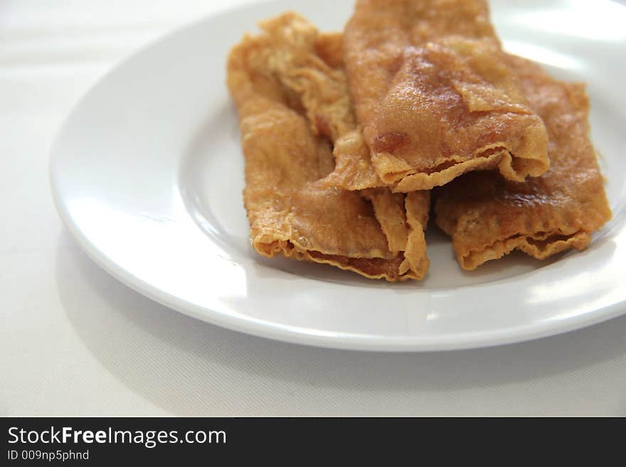 Deep fried flat spring rolls with boiled fish paste rolled in soy scum skin. Deep fried flat spring rolls with boiled fish paste rolled in soy scum skin