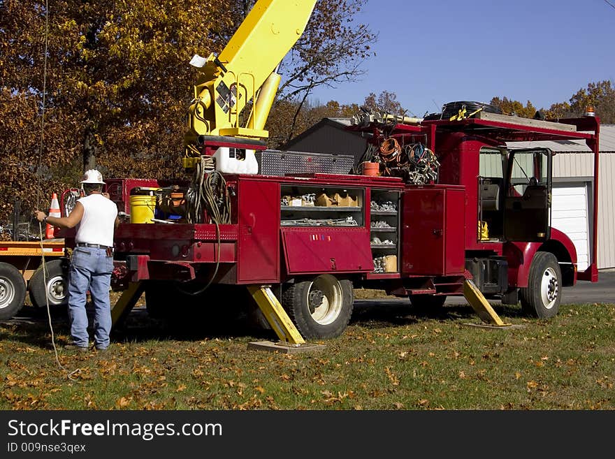 An electrical worker adds a new line to a utility pole. An electrical worker adds a new line to a utility pole.