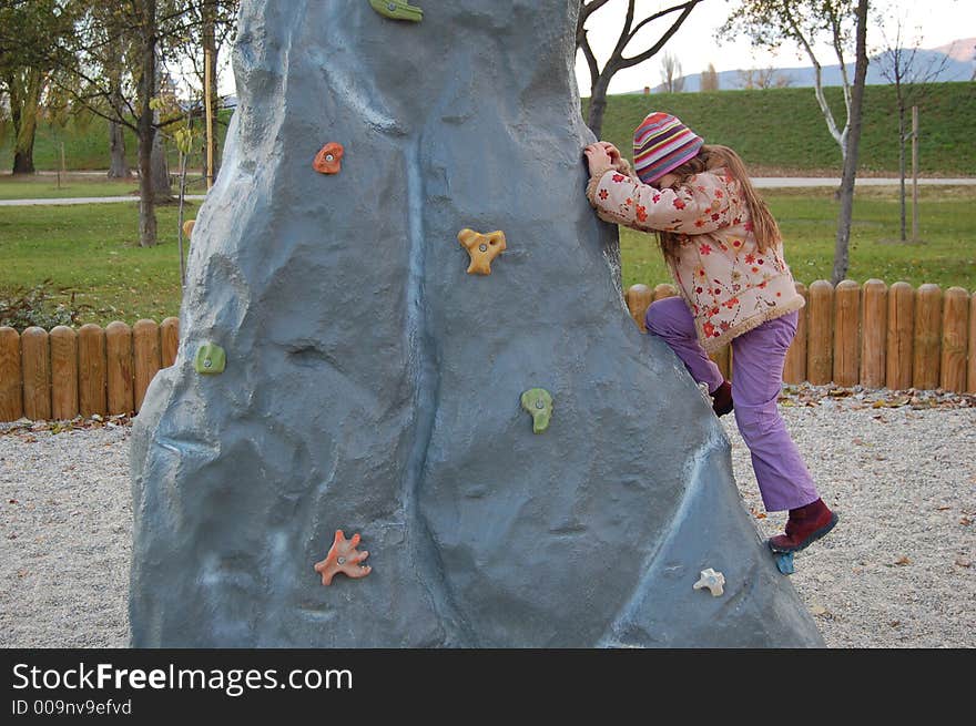 Child climbing a playground hill. Child climbing a playground hill.