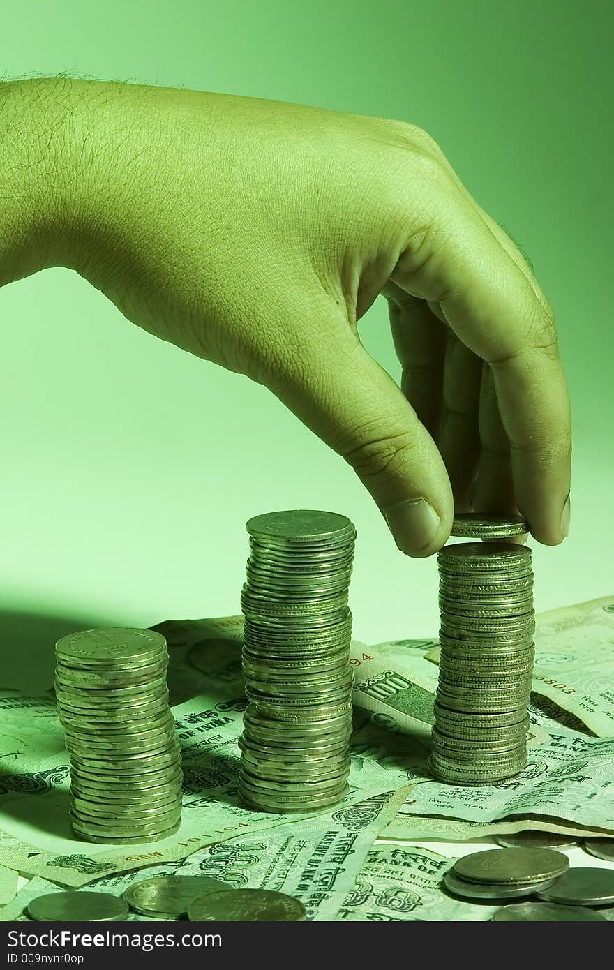 Man's hand placing coin on stack of change